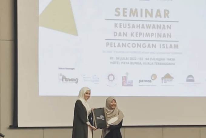 Presentation of a token on stage at a seminar on Islamic tourism entrepreneurship and leadership.