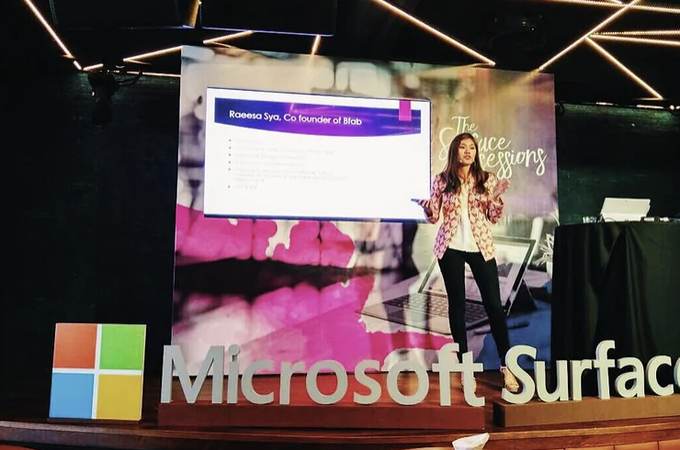 Raeesa Sya presenting on stage at a Microsoft Surface session.